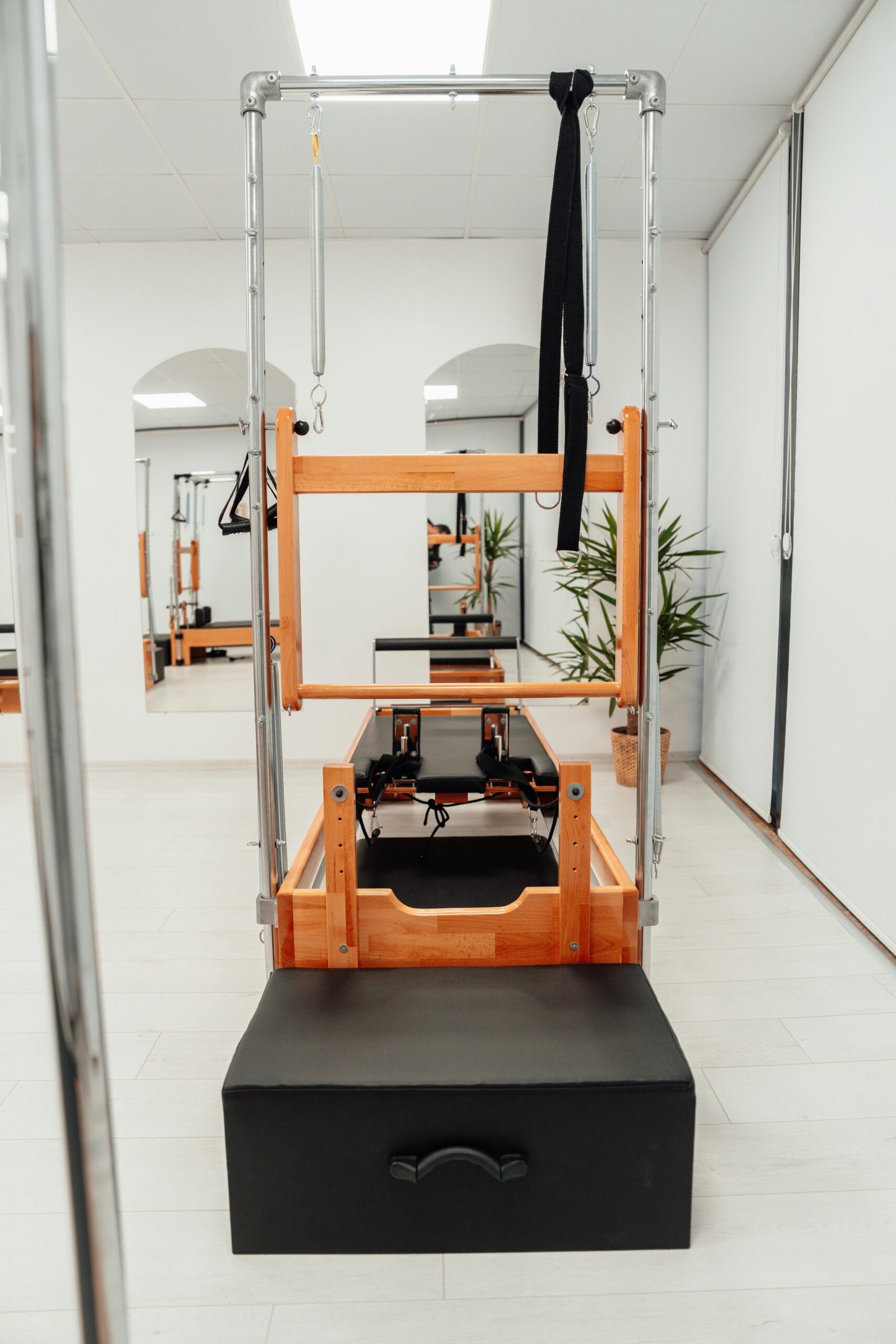 Pilates clínico em consultório de fisioterapia com reformer e paciente em movimento controlado sob orientação de fisioterapeuta, luz natural e ambiente clínico humanizado.